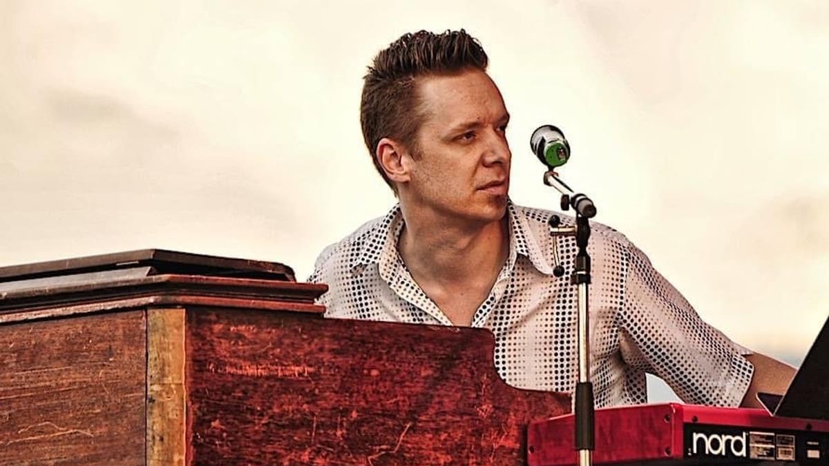 Keyboardist Adam Klipple performing behind piano and electronic keyboards