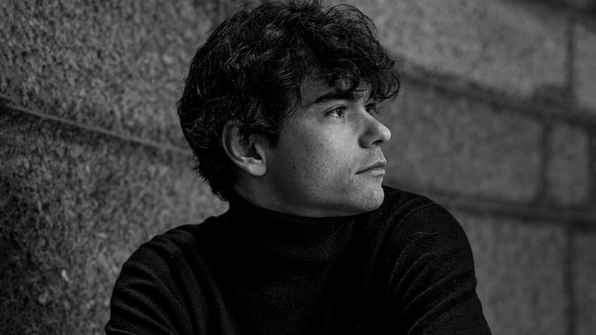 Pianist Tom Borrow, a white man in a black turtleneck, looks to the side in this black and white photo.