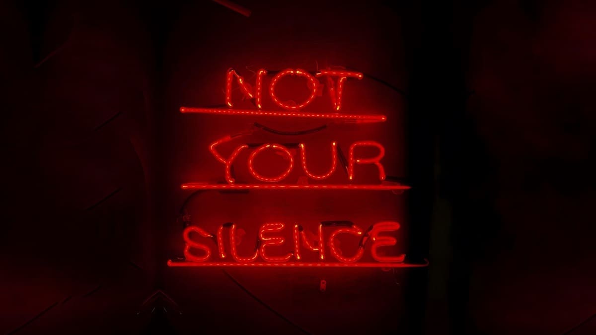 Red neon artwork reading Not Your Silence