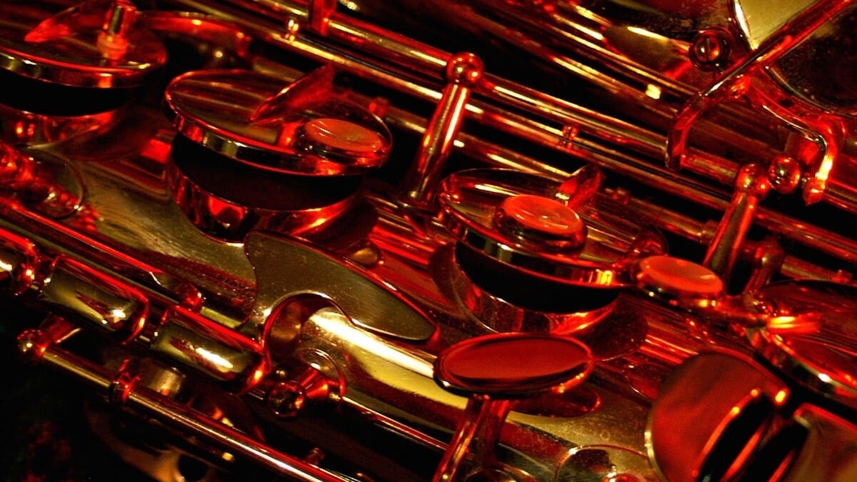 Close-up of saxophones under red stage lighting