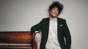 Cuban pianist Jorge Luis Pacheco beside a piano