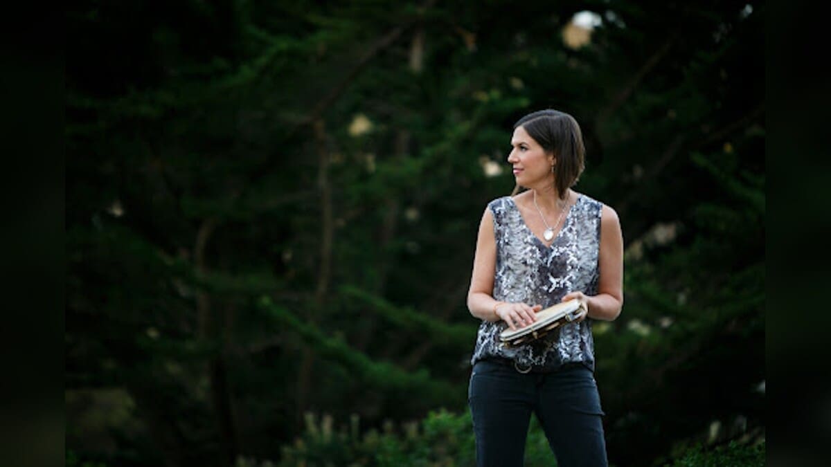 Ami Molinelli holding a percussion instrument outdoors