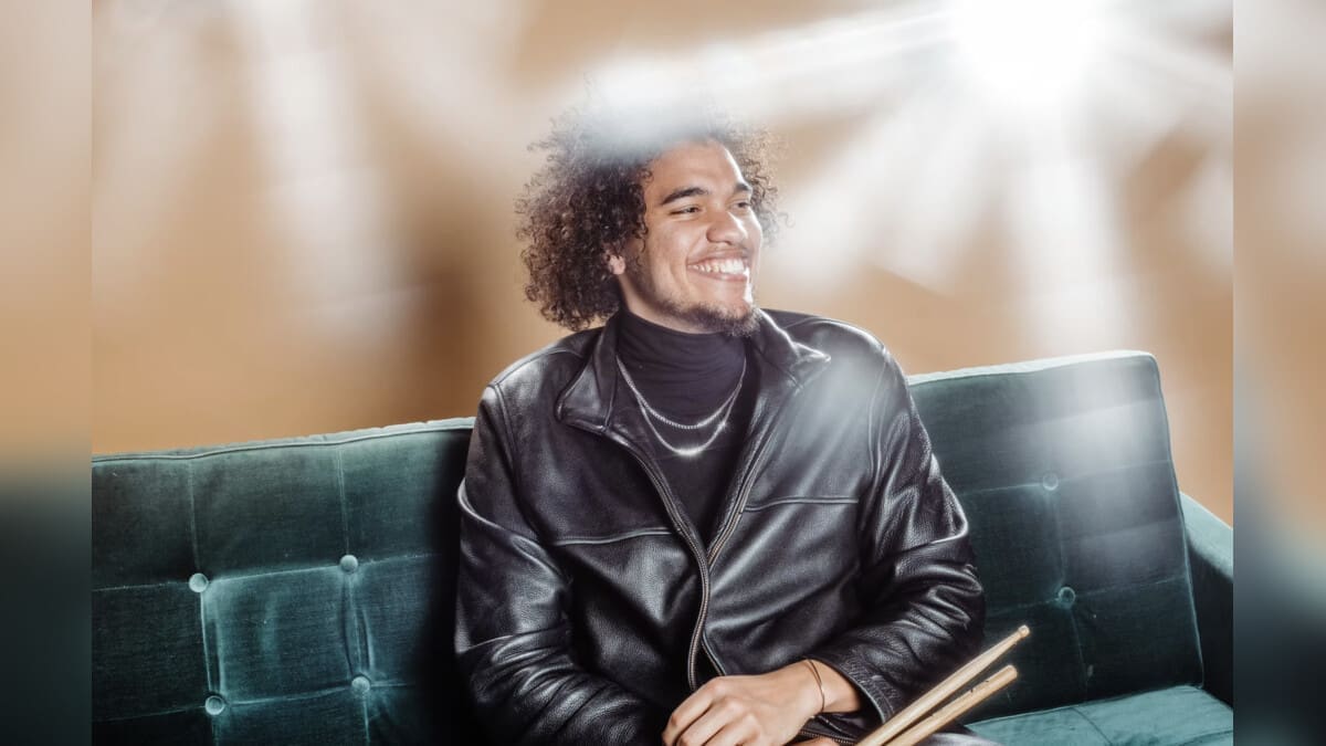 Elé Howell seated with drumsticks