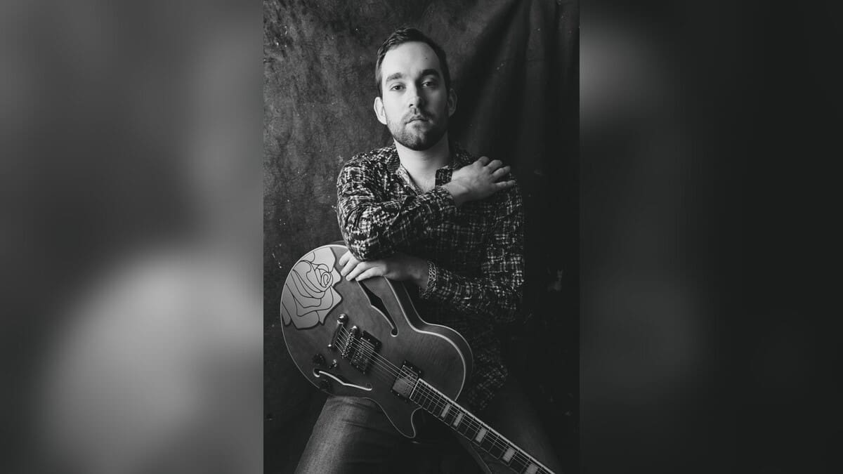 Cody Steinmann holding a guitar