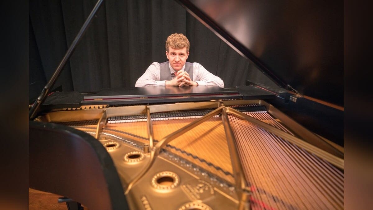 Joe Warner seated at a grand piano