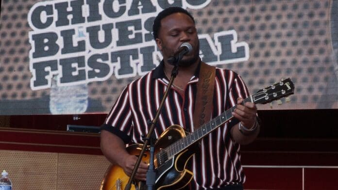 Jontavious Willis singing and playing guitar at the Chicago Blues Festival.