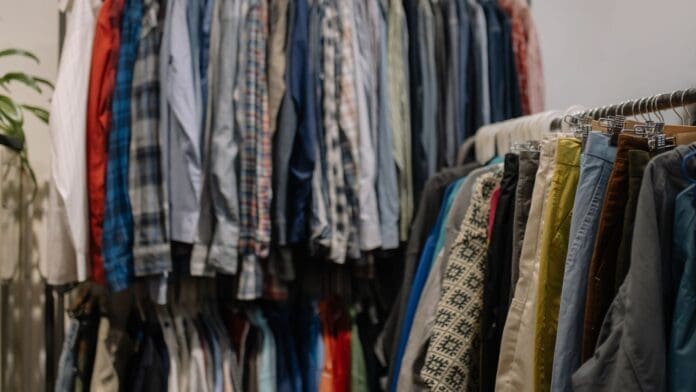 Assorted clothes hanging on clothing racks.