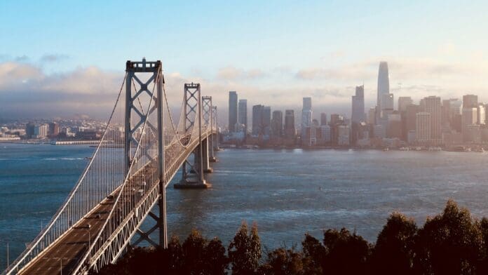 The Bay Bridge leading toward the San Francisco skyline at sunset.