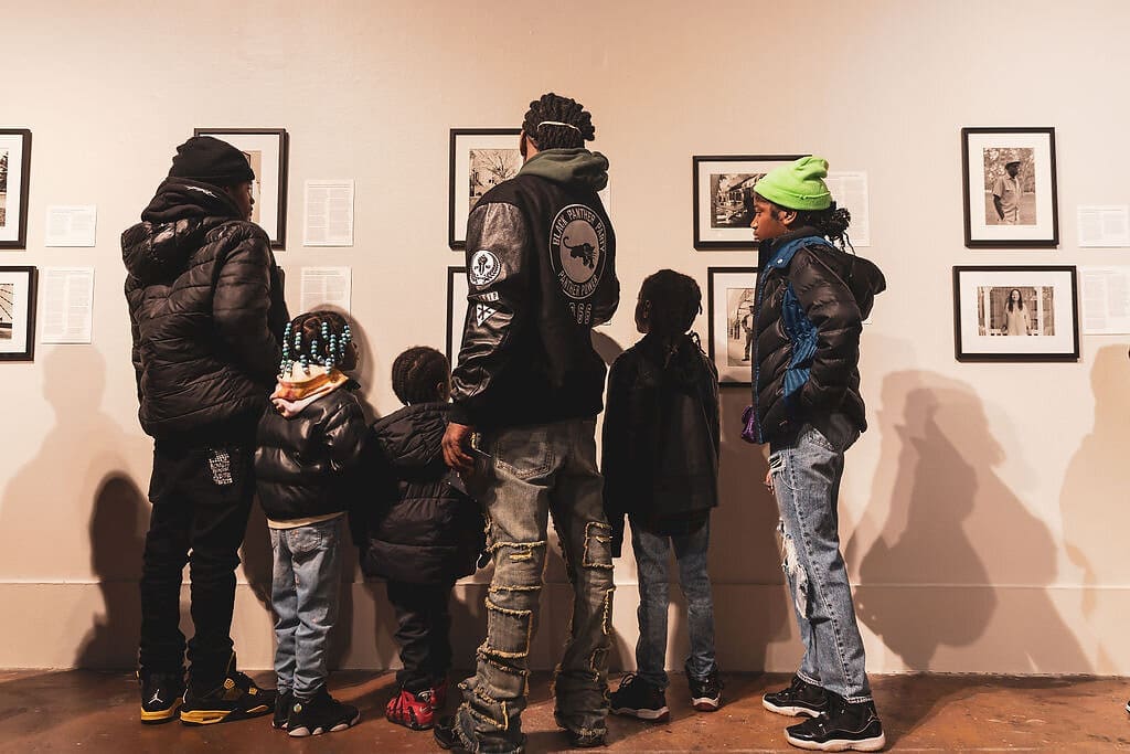 Adults and children viewing exhibits at the Black Panther Party Museum in downtown Oakland