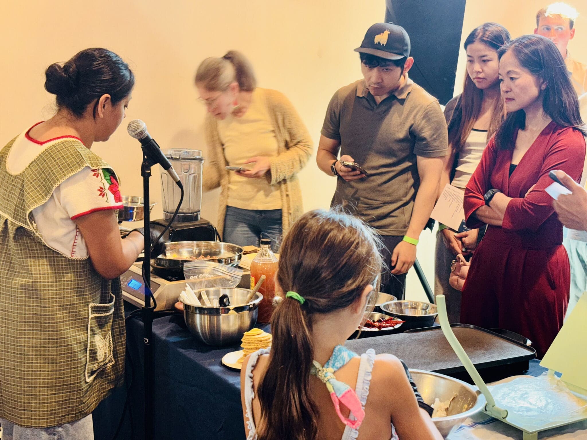 Visitors gather around a cooking demonstration.
