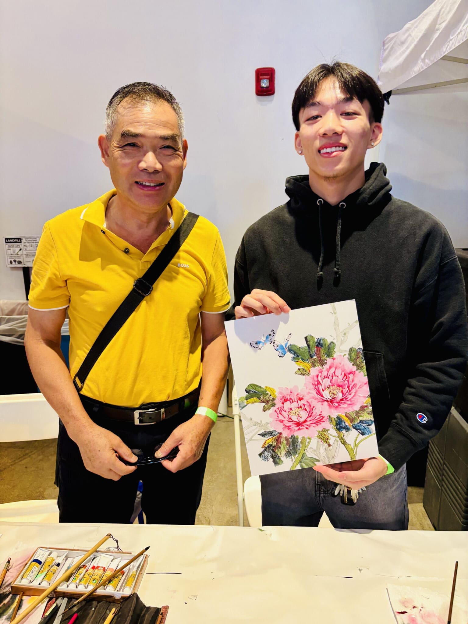 Two exhibitors display a floral artwork at The Edible Atlas.