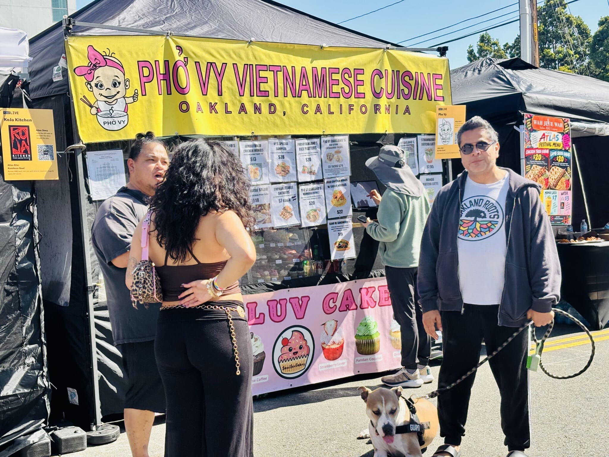 A festivalgoer in an Oakland Roots shirt with his dog at The Edible Atlas.