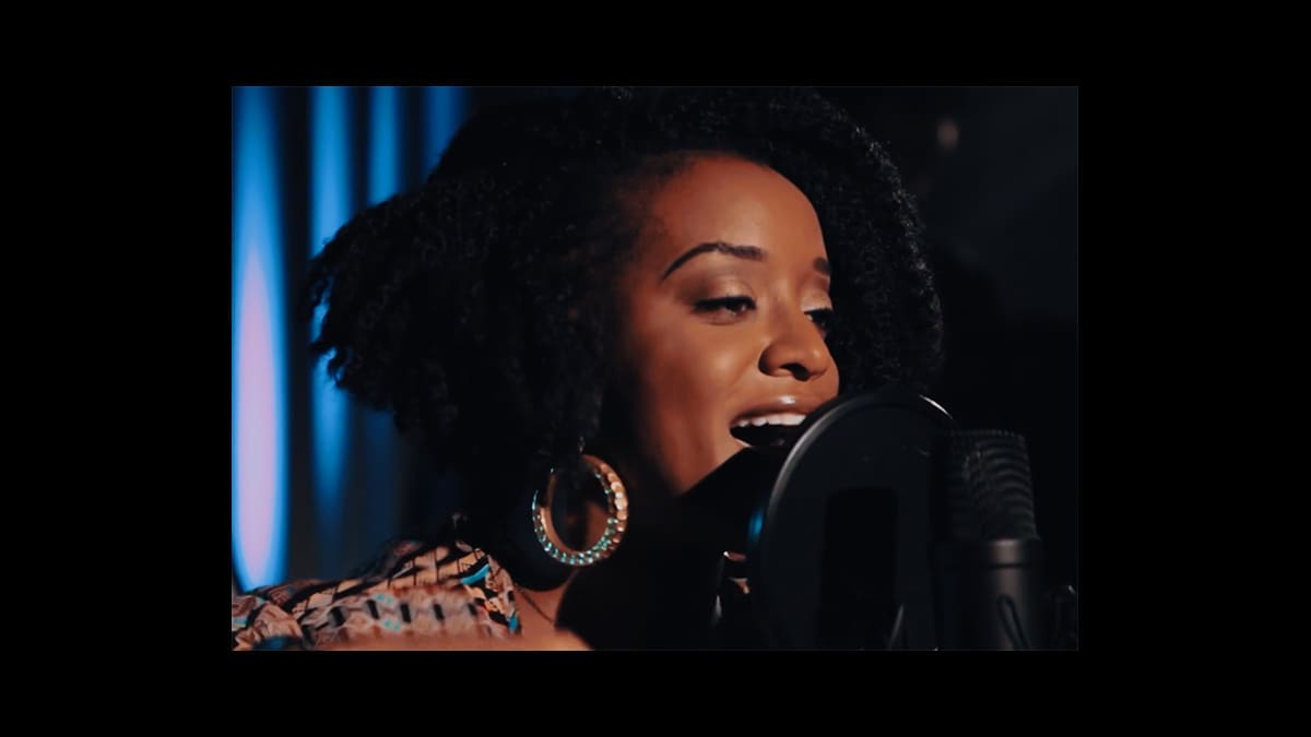 RyanNicole performing at a microphone in an official Oakland Originals documentary still.